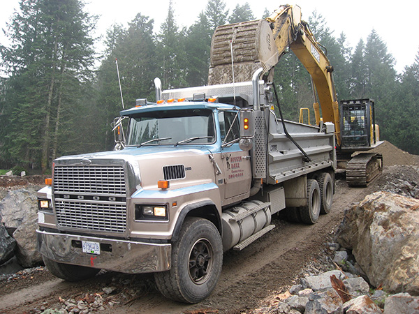 An excavator and filling a loader truck